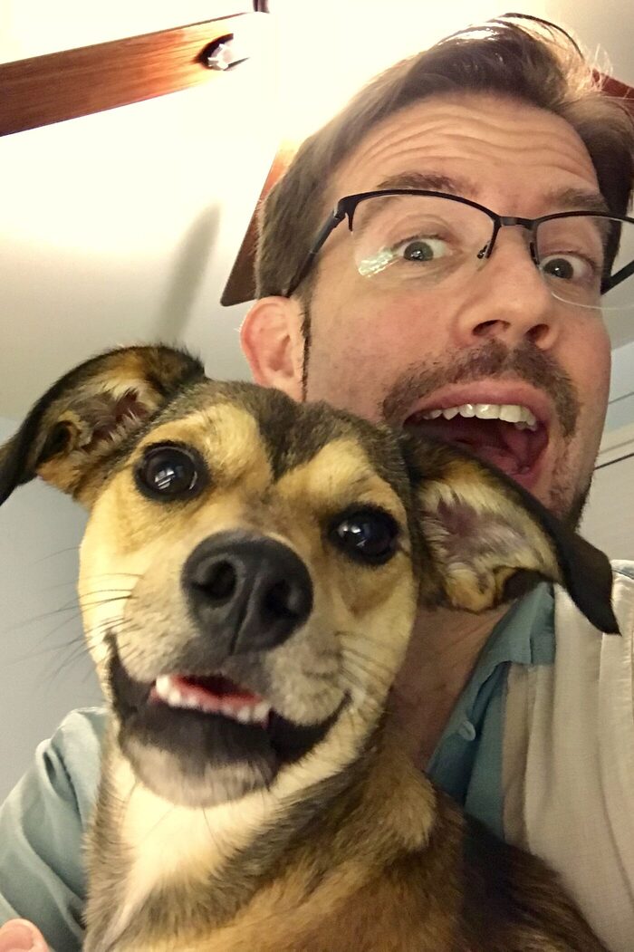 David Citron and one of his dogs, cheek to cheek, both mugging at the camera